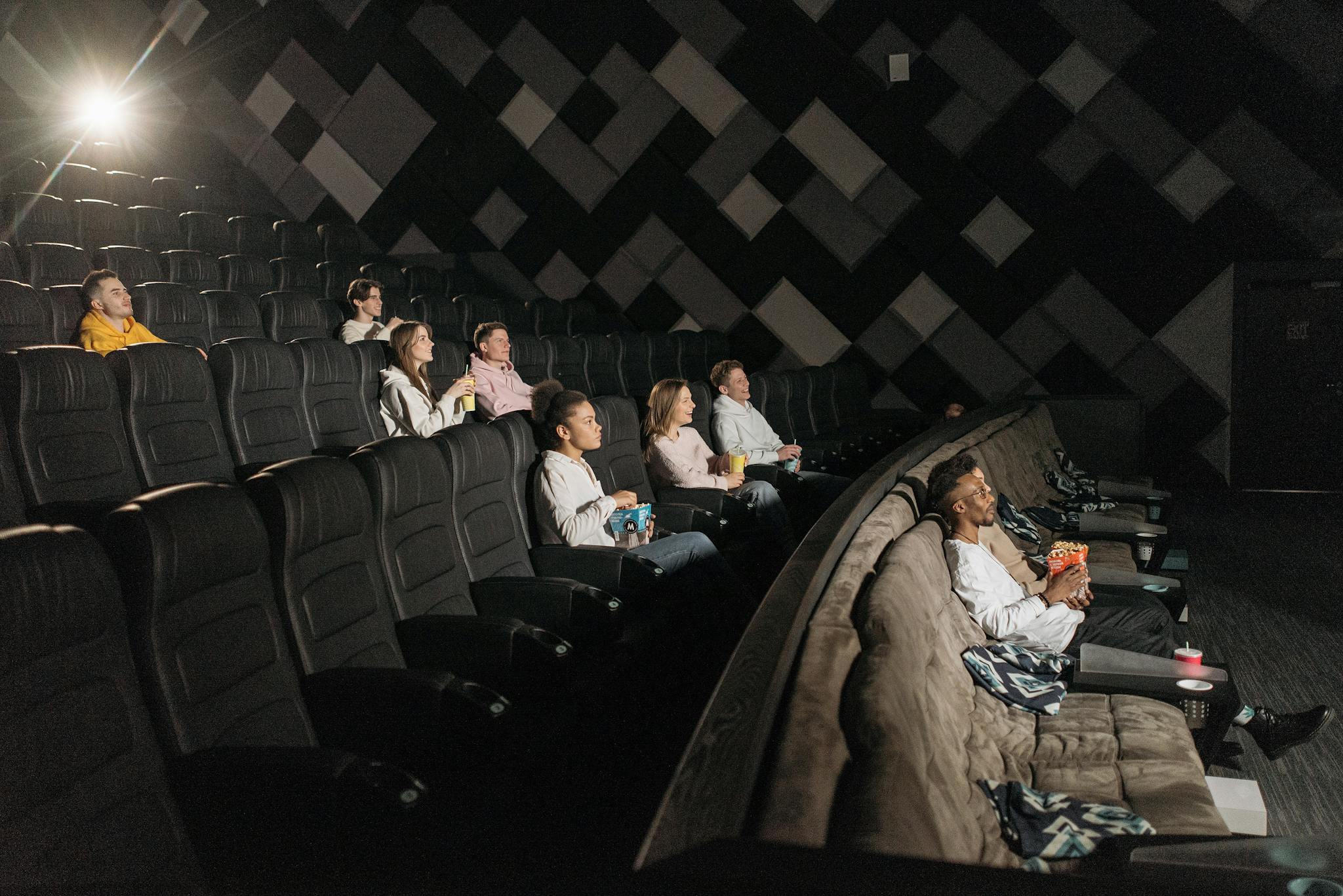 About Audience enjoying a film screening in a modern theater with popcorn and drinks.